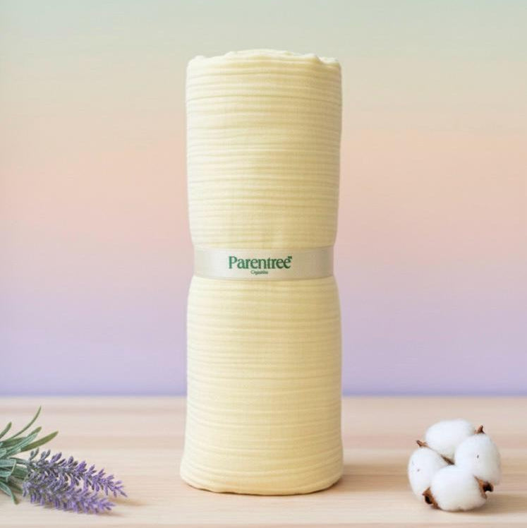 Stack of rolled-up towels with 'ParenTree' branding on a wooden surface with a blurred background