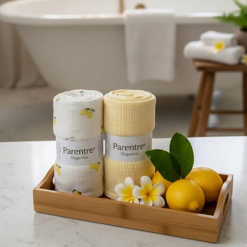 Two rolls of Parentre organic towels on a tray with lemons and flowers in a bathroom setting.