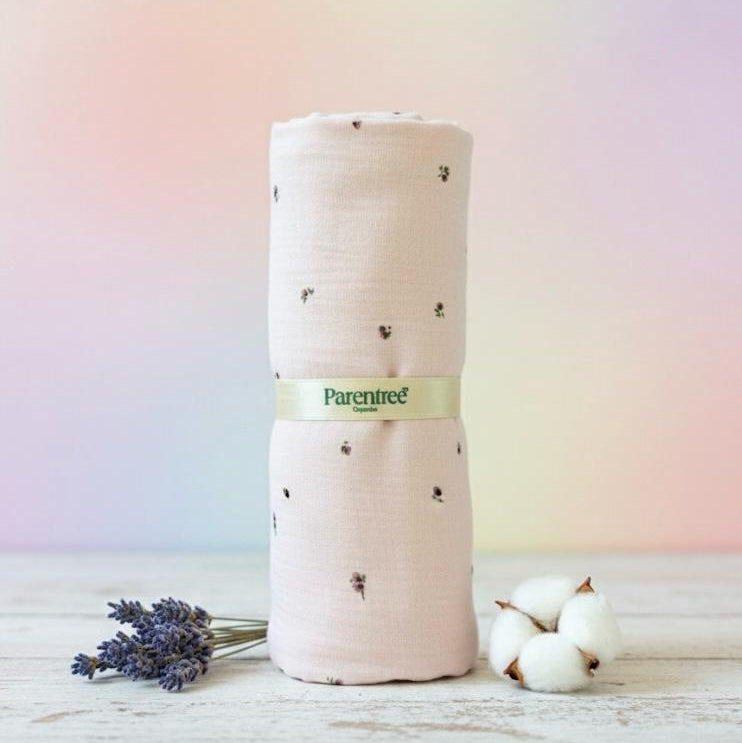 Rolled-up fabric with 'Parentree' label on a wooden surface with lavender and cotton flowers.